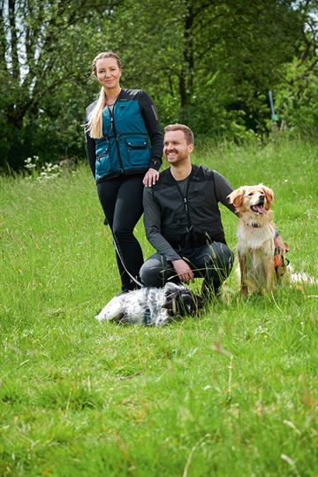 Dame og herre i Owney træningsvest med hunde