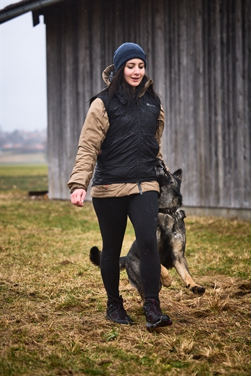 Kvinde i træningsvest med hund