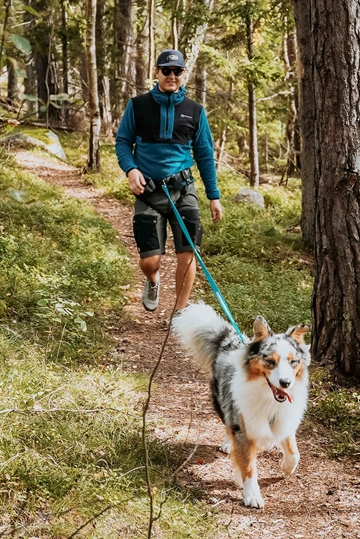 Mand på løbetur med hund i skov